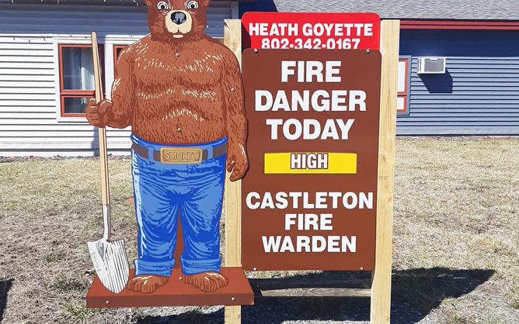 Smokey the bear sign, in front of Fire House, showing forrest fire hazards with contact information for Castleton Fire Warden